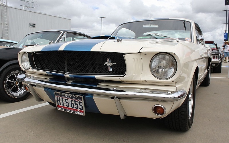 A white 1965 Shelby Mustang GT350 with blue stripes